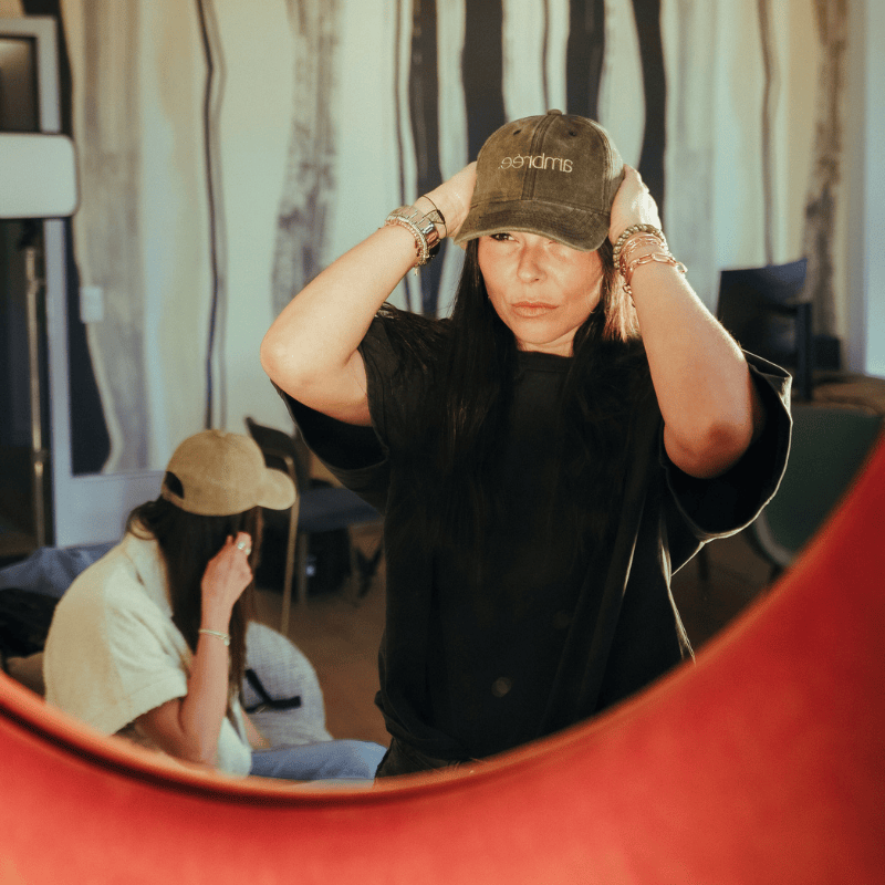 Femme de profil portant une casquette Ambrée brodée, reflet en arrière-plan