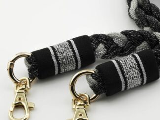 Gros plan sur le cordon Baroque Bohème Ambrée noir et blanc avec embouts rayés et mousquetons dorés